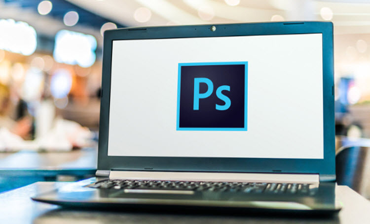 A student practicing basic Photoshop techniques on a laptop during a beginner’s training session.